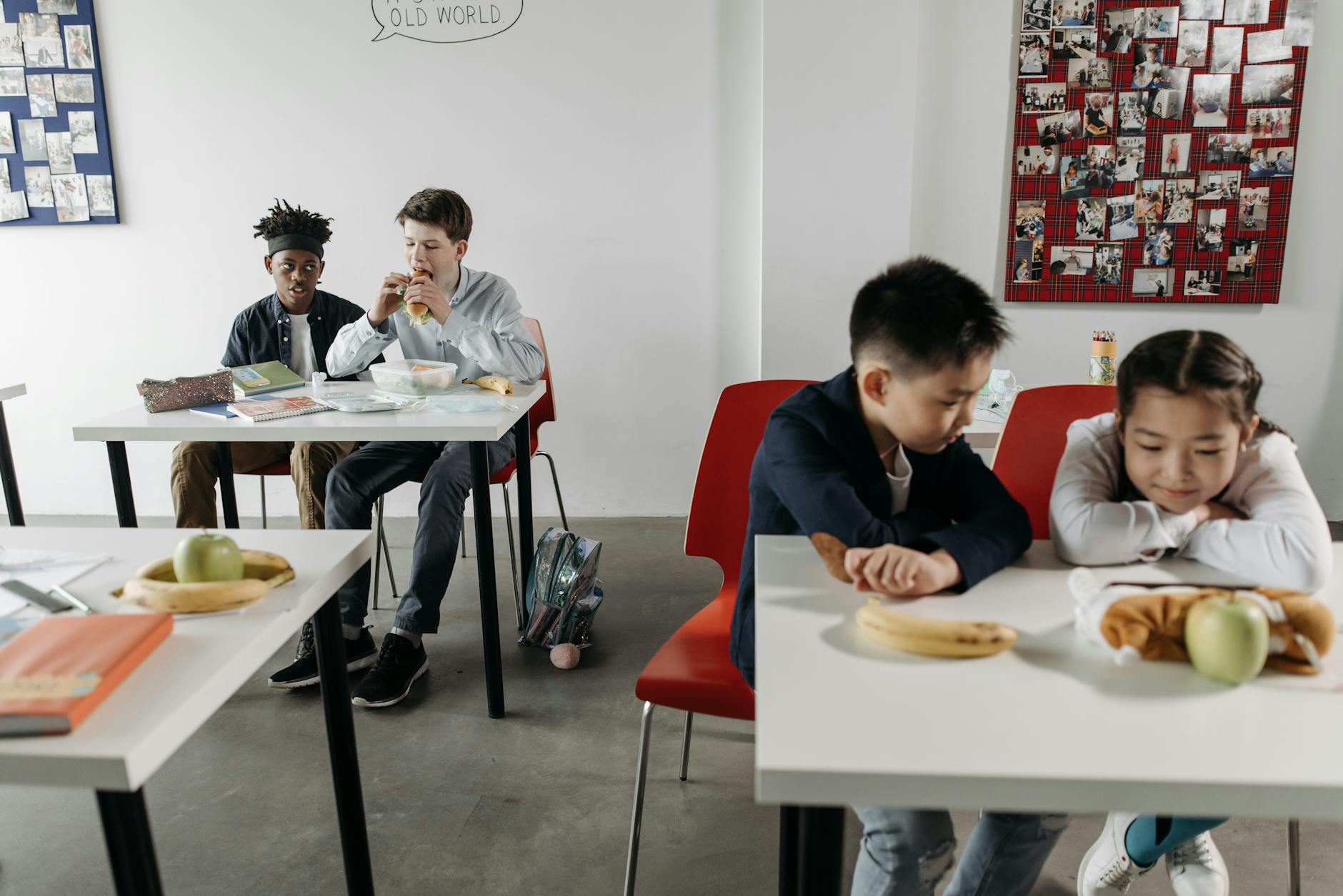 Dzieci różnych narodowości jedzą szkolny obiad w nowoczesnej klasie