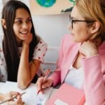 Jak wspierać uczniów z ubogich rodzin: stypendia, zasiłki, dożywianie i źródła finansowania Nauczyciel pomaga nastolatkowi przy szkolnym projekcie w klasie