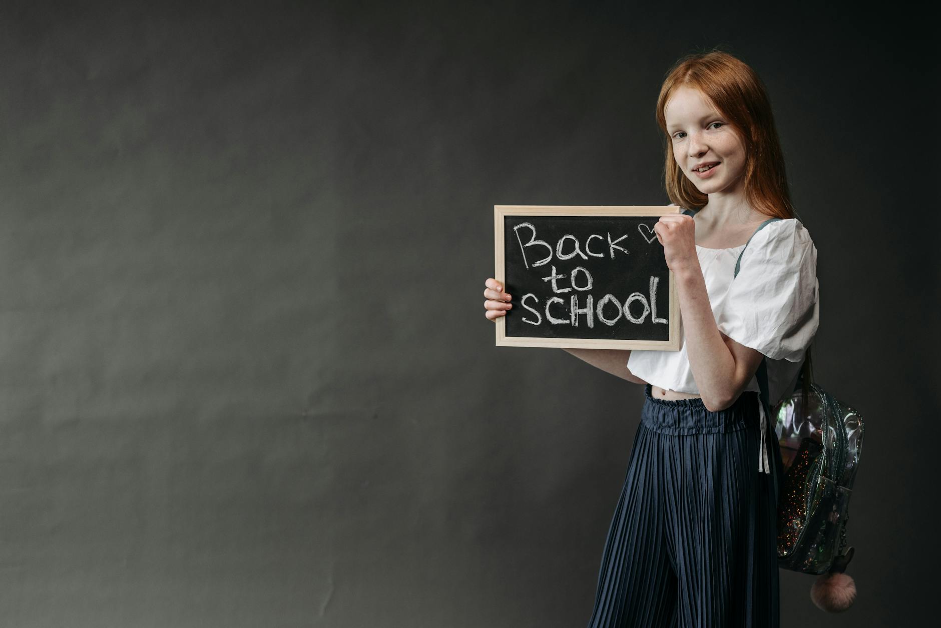 Dziewczynka trzymająca tabliczkę z napisem Back to School