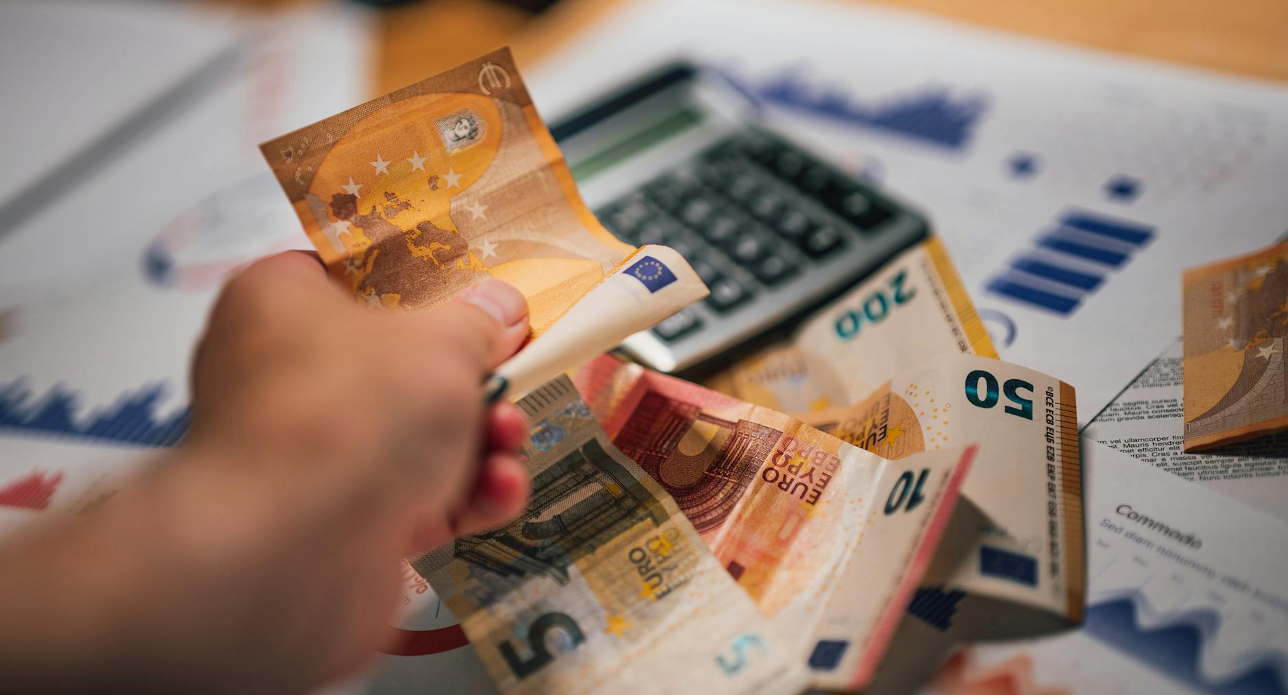 Banknoty euro, dokumenty finansowe i kalkulator przy planowaniu wydatków