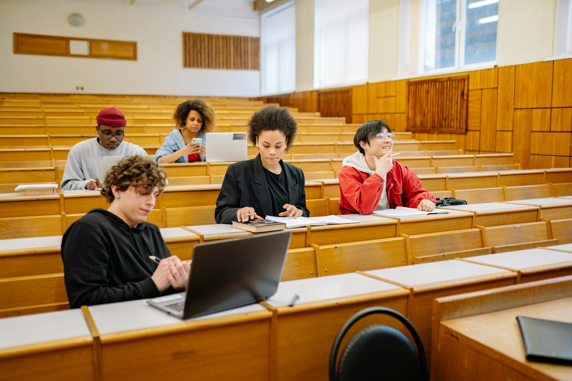 Jak działa USOS i czemu warto go ogarnąć w pierwszym tygodniu na uczelni Studenci na uczelni uczą się razem przy laptopach i książkach