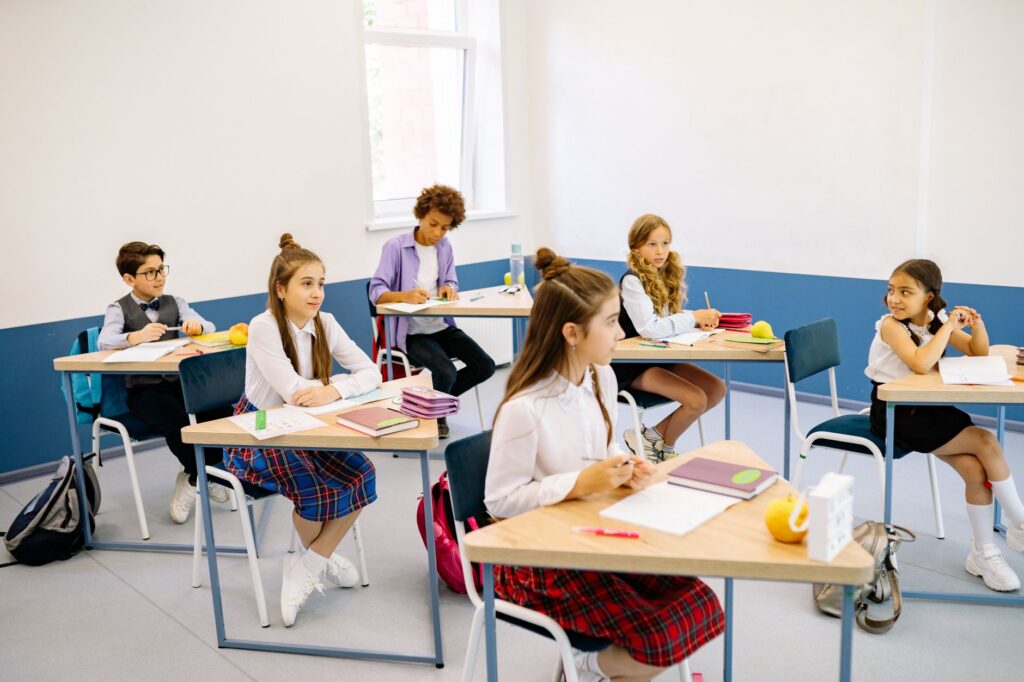 Uczniowie podczas lekcji w jasnej, różnorodnej klasie szkolnej